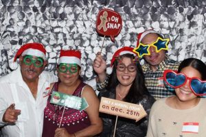 Group wearing Santa hats and novelty glasses