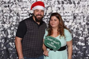 Couple with Santa hat and holiday sign