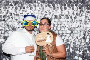 Two people in photo booth with novelty props