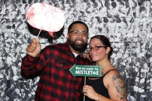 Smiling couple with mistletoe sign