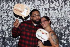 Smiling couple holding holiday photo props