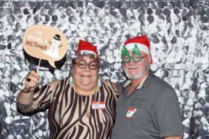 Couple in holiday photo booth wearing Santa hats