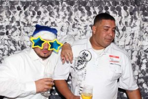 Two men at party, one with star glasses