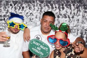 Three friends wearing festive holiday props