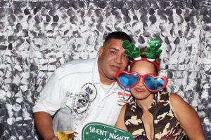 Festive couple wearing reindeer antlers, heart sunglasses