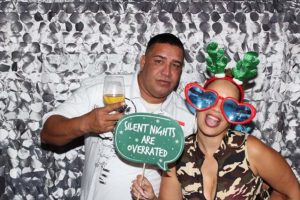 Couple posing with festive props and sign