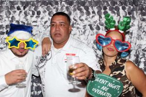 Three friends in holiday photo booth with props