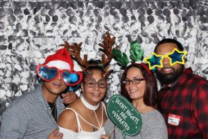 Four people in holiday photo booth props