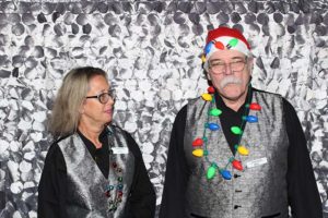 Two people in silver vests with Christmas lights