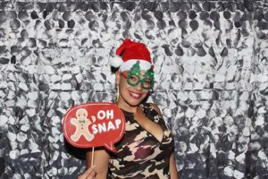 Smiling woman wearing Santa hat and Christmas glasses