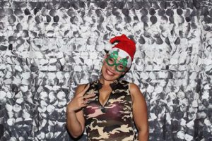 Person wearing Santa hat and green glasses
