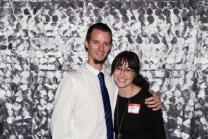 Smiling couple posing against silver sequin backdrop