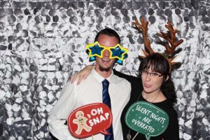 Two people in photo booth with props