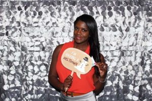 Smiling woman holding speech-bubble prop