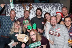 Smiling group wearing holiday props in photobooth