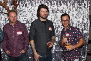 Three men at party holding drinks