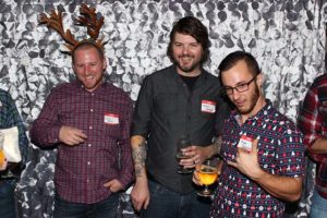 Three men at holiday party with drinks