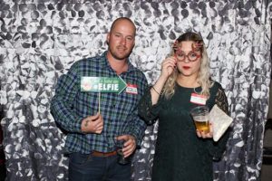 Two people in photo booth with festive props