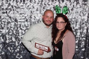 Couple posing with reindeer antlers and sign