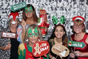 Women in Christmas photo booth with props