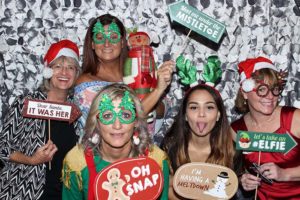 Group of women posing with Christmas props