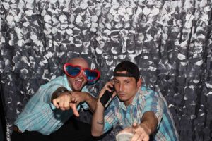 Two men partying in photobooth with props