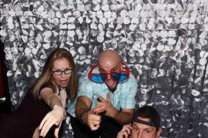 Three friends posing playfully in photo booth