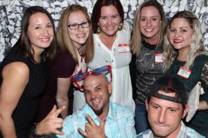 Seven friends smiling in a photo booth