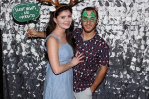 Couple wearing antlers and Christmas glasses