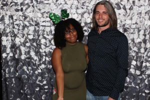 Smiling couple by silver sequin backdrop
