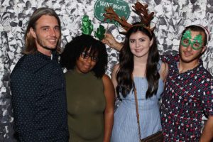 Four people posing with holiday photo props