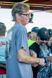 Two men smiling at motorcycle event