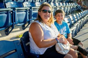 Woman and boy smiling in stadium seats