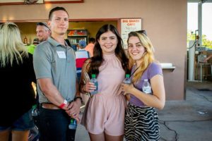 Three people smiling, holding water bottles