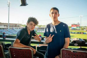 Two teenage boys posing at baseball stadium
