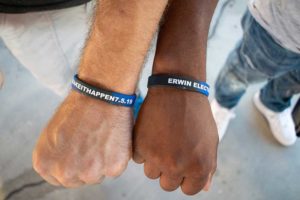 Two fists wearing blue and black wristbands