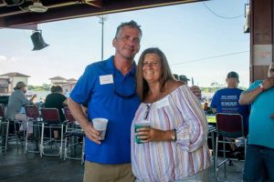 Couple smiling and holding drinks at event