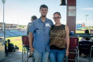Smiling couple posing at baseball stadium