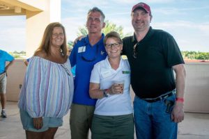 Group of four smiling adults outdoors