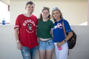 Three smiling people posing at outdoor venue