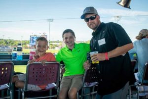 Man and two boys at baseball stadium
