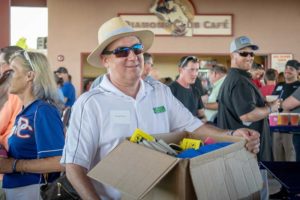 Smiling man in straw hat carrying box