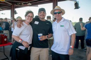 Three people smiling at outdoor event