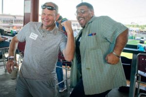 Two men laughing and posing at ballpark