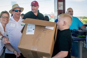 Boy carrying large cardboard box at outdoor event